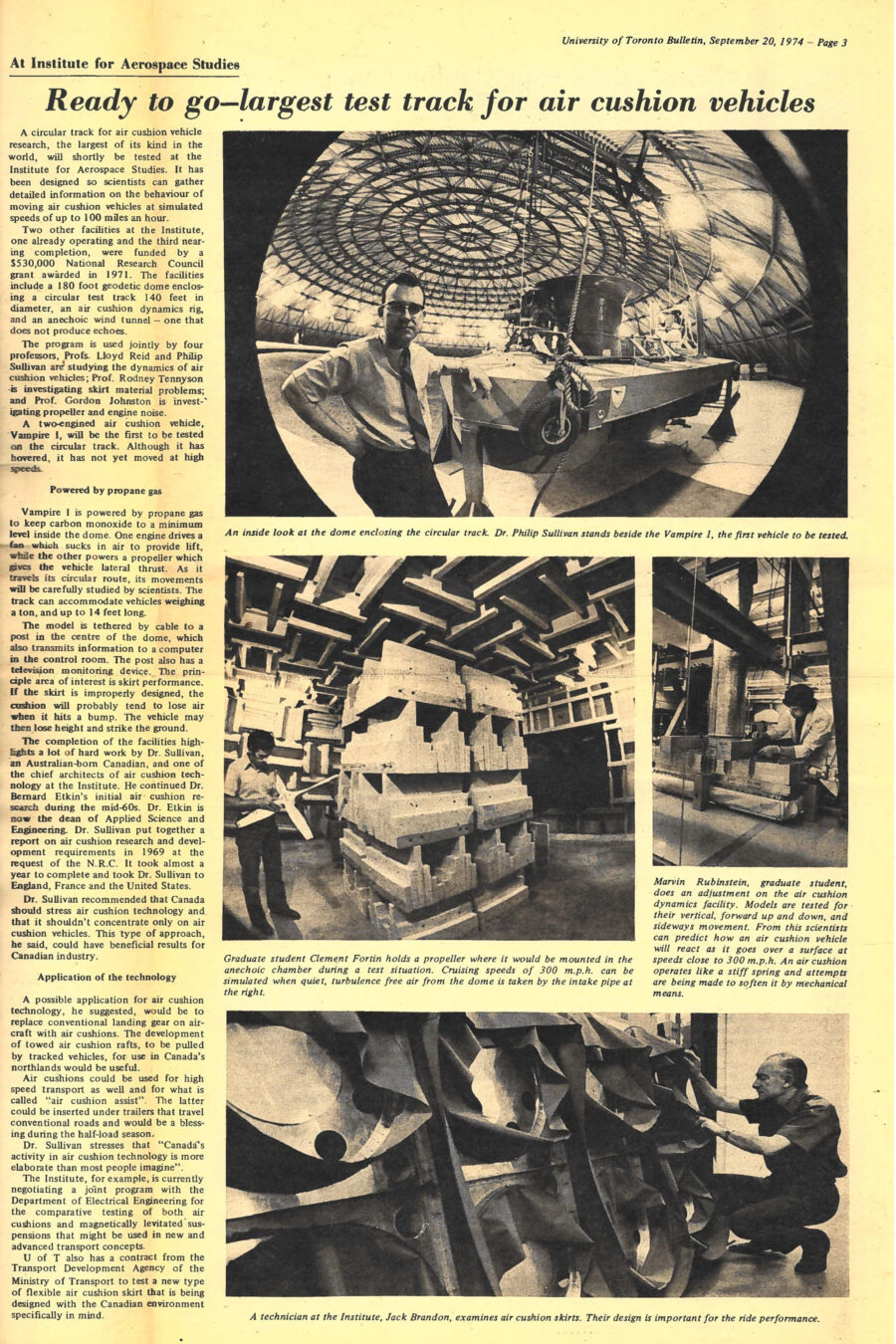Newspaper clipping from University of Toronto Bulletin, September 20, 1974
Headline: Ready to go – largest test track for air cushion vehicles
Photo 1: A man in short sleeves and dress pants holds a two-foot-long propeller, standing beside the unusual angular foam shapes of an anechoic chamber. 
Caption: Graduate student Clement Fortin holds a propeller where it would be mounted in the anechoic chamber during a test situation. Cruising speeds of 300 miles per hour can be simulated when quiet, turbulence free air from the dome is taken by the intake pipe at right.
Photo 2: A man in a lab coat adjusts a large piece of equipment.
Caption: Marvin Rubinstein, graduate student, does an adjustment on the air cushion dynamics facility. Models are tested for their vertical, forward up and down, and sideways movement. From this scientists can predict how an air cushion vehicle will react as it goes over a surface at speeds close to three hundred miles per hour. An air cushion operates like a stiff spring and attempts are being made to soften it by mechanical means.
Photo 3: A man in work clothes kneels as he examines the large side of an air cushion.
Caption: A technician at the Institute, Jack Brandon, examines air cushion skirts. Their design is important for the ride performance.
A circular track for air cushion vehicle research, the largest of its kind in the world, will shortly be tested at the Institute for Aerospace Studies. It has been designed so scientists can gather detailed information on the behaviour of moving air cushion vehicles at simulated speeds of up to one hundred miles an hour.
Two other facilities at the Institute, one already operating and the third near completion, were funded by a $530,000 National Research Council grant awarded in 1971. The facilities include a one-hundred-and-eighty-foot geodetic dome enclosing a circular test track one-hundred-and-forty-feet in diameter, an air cushion dynamics rig, and an anechoic wind tunnel – one that does not produce echoes.
The program is used jointly by four professors, Professors Lloyd Reid and Philip Sullivan are studying the dynamics of air cushion vehicle; Professor Rodney Tennyson is investigating skirt material problems; and Professor Gordon Johnston is investigating propeller and engine noise.
A two-engined air cushion vehicle, Vampire I, will be the first to be tested on the circular track. Although it has hovered, it has not yet moved at high speeds. Vampire I is powered by propane gas to keep carbon monoxide to a minimum level inside the dome. One engine drives a fan which sucks in air to provide lift, while the other powers a propeller which gives the vehicle lateral thrust. As it travels its circular route, its movements will be carefully studied by scientists. The track can accommodate vehicles weighing a ton, and up to fourteen feet long.
The model is tethered by cable to a post in the centre of the dome, which also transmits information to a computer in the control room. The post also has a television monitoring device. The principle area of interest is skirt performance. If the skirt is improperly designed, the cushion will probably tend to lose air when it hits a bump. The vehicle may then lose height and strike the ground.
The completion of the facilities highlights a lot of hard work by Doctor Sullivan, an Australian-born Canadian, and one of the chief architects of air cushion technology at the Institute. He continued Doctor Bernard Etkin’s initial air cushion research during the mid-sixties. Doctor Etkin is now the dean of Applied Science and Engineering. Doctor Sullivan put together a report on air cushion research and development requirements in 1969 at the request of the National Research Council. It took almost a year to complete and took Doctor Sullivan to England, France and the United States.
Doctor Sullivan recommended that Canada should stress air cushion technology and that it should not concentrate only on air cushion vehicles. This type of approach, he said, could have beneficial results for Canadian industry. A possible application for air cushion technology, he suggested, would be to replace conventional landing gear on aircraft with air cushions. The development of towed air cushion rafts, to be pulled by tracked vehicles, for use in Canada’s northlands would be useful.
Air cushions could be used for high speed transport as well and for what is called “air cushion assist.” The latter could be inserted under trailers that travel conventional roads and would be a blessing during the half-load season.
Doctor Sullivan stresses that “Canada’s activity in air cushion technology is more elaborate than most people imagine.” The Institute, for example, is currently negotiating a joint program with the Department of Electrical Engineering for the comparative testing of both air cushions and magnetically levitated suspensions that might be used in new and advanced transport concepts.
University of Toronto also has a contract from the Transport Development Agency of the Ministry of Transport to test a new type of flexible air cushion skirt that is being designed with the Canadian environment specifically in mind.